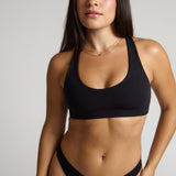 woman wearing black racerback on plain background
