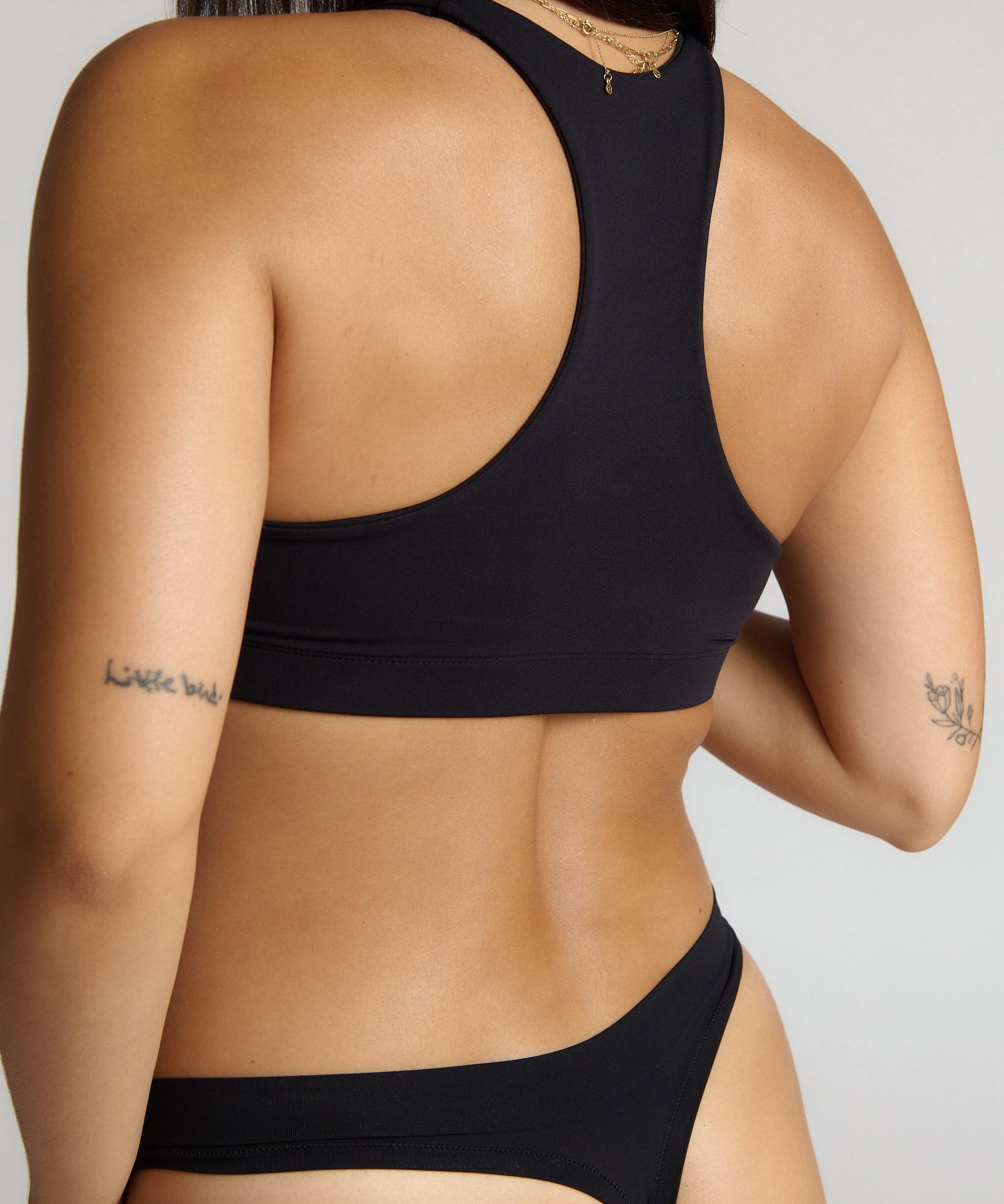 woman wearing black racerback on plain background