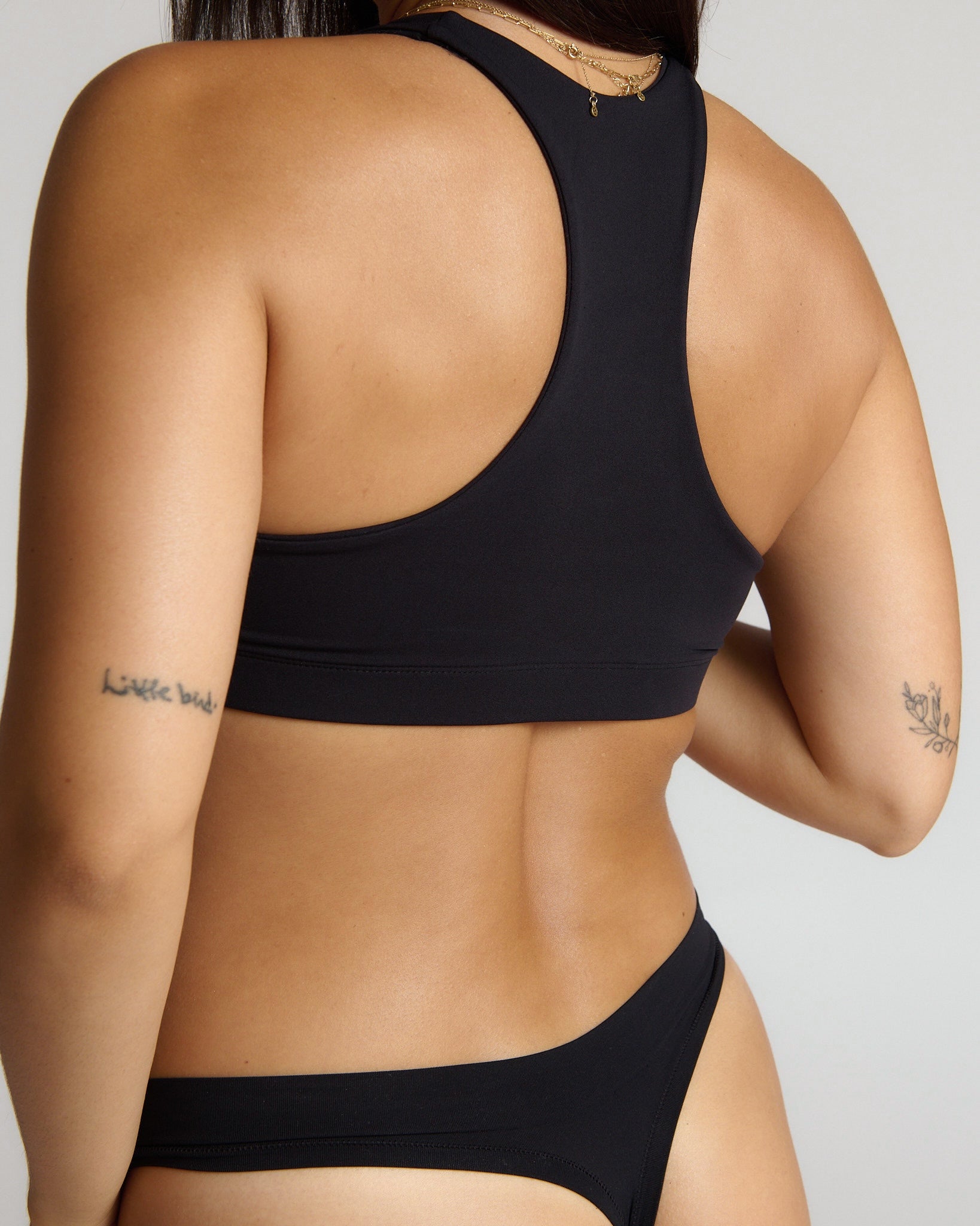 woman wearing black racerback on plain background