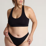 woman wearing black racerback on plain background