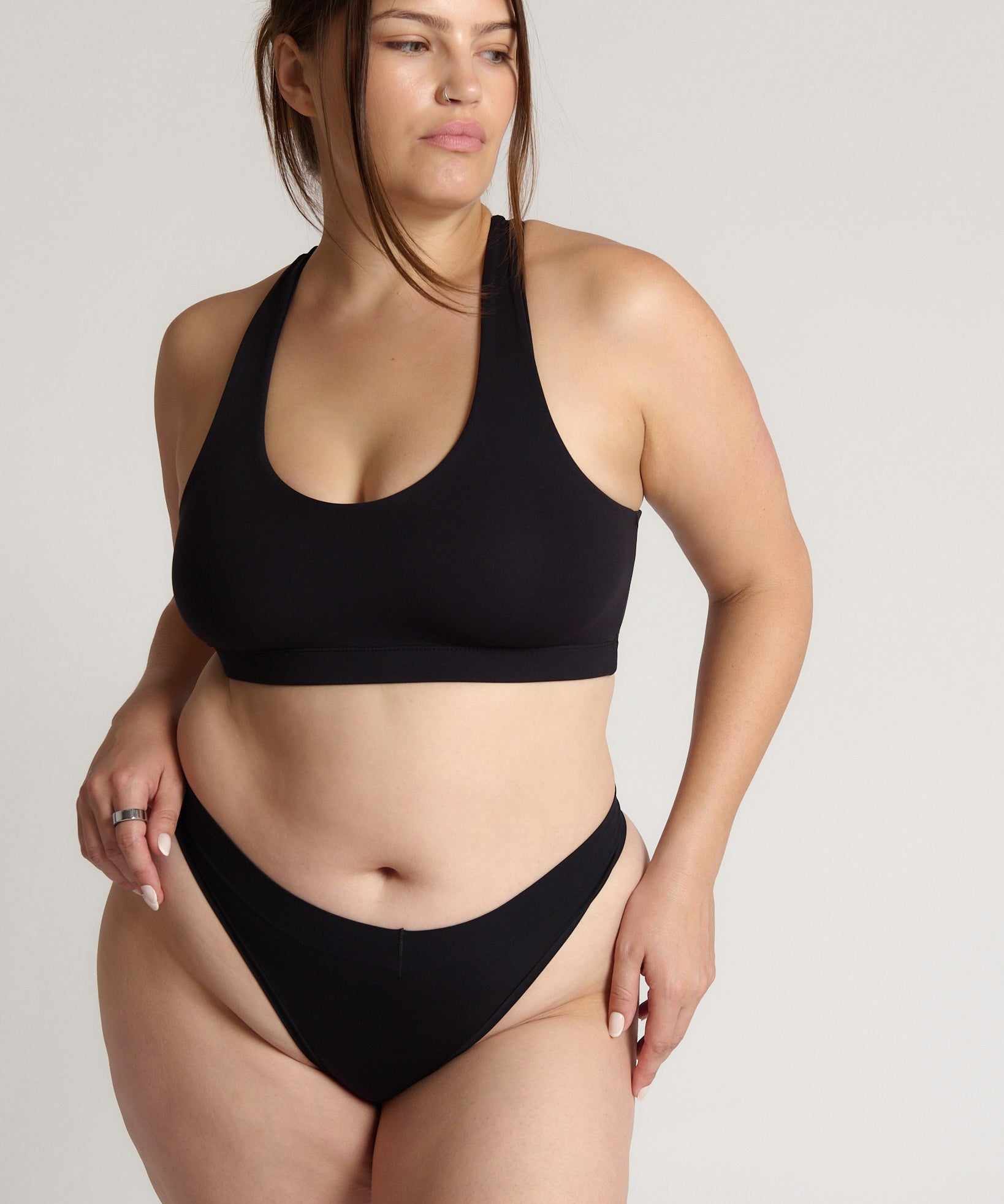 woman wearing black racerback on plain background
