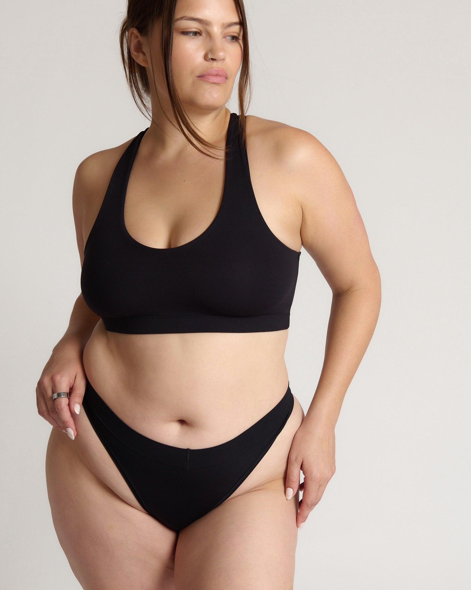 woman wearing black racerback on plain background