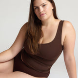 Woman wearing a brown tank top against a white background