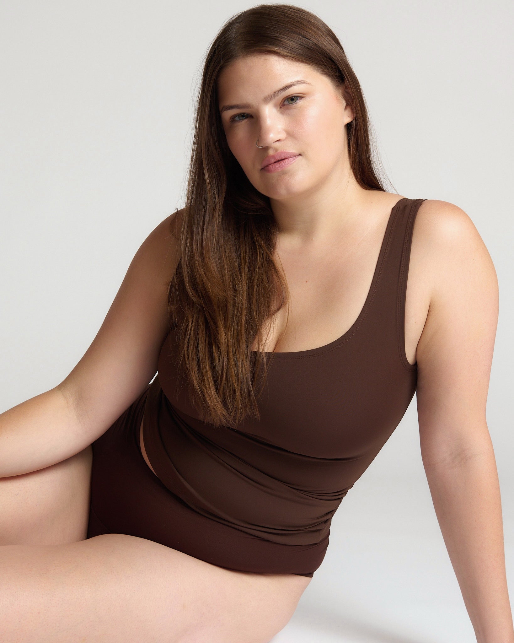 Woman wearing a brown tank top against a white background
