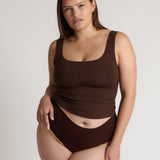Woman wearing a brown tank top against a plain background