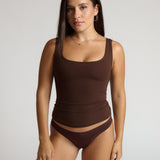 Woman wearing a brown tank top against a white background