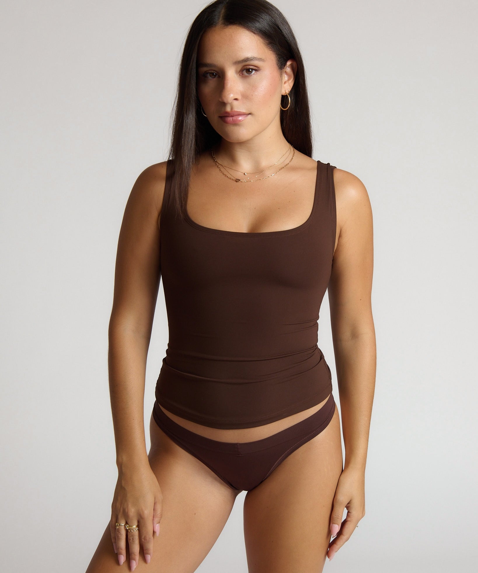 Woman wearing a brown tank top against a white background