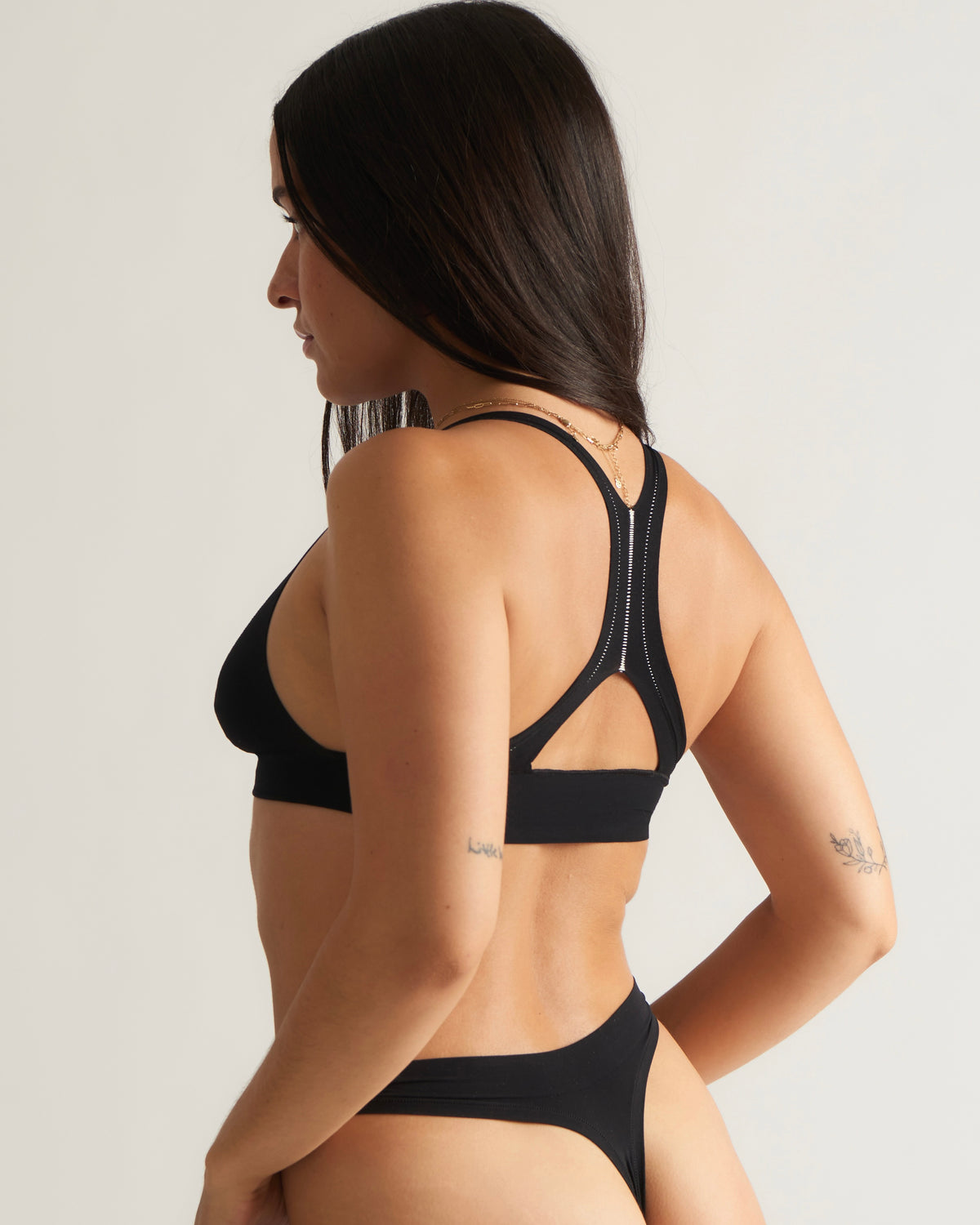 Woman standing wearing Racerback System and Thong in black 
