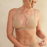 Woman wearing a light bra and matching thong with a deep v-neckline.