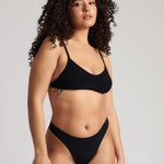 Woman wearing black scoop system against a neutral background