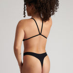 Woman wearing black scoop system against a neutral background