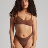 A woman wearing a brown scoop system and matching bottoms