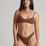 A woman wearing a brown scoop system and matching bottoms