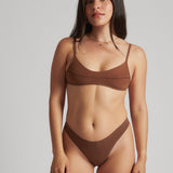 A woman wearing a brown scoop system and matching bottoms