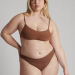 A woman wearing a brown scoop system and matching bottoms