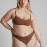 A woman wearing a brown scoop system and matching bottoms