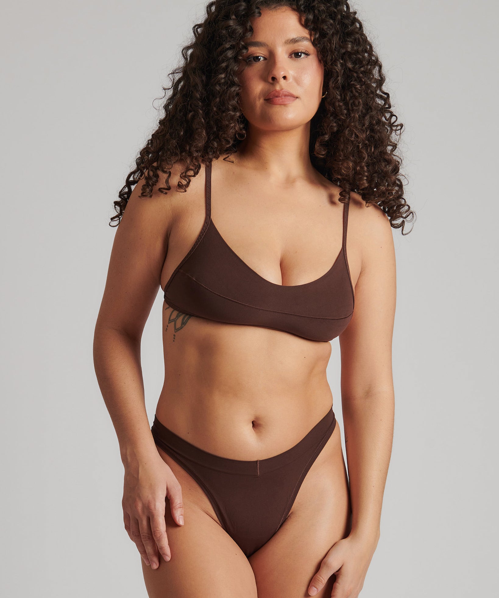 A person wearing a brown thong and scoop system on a plain background.