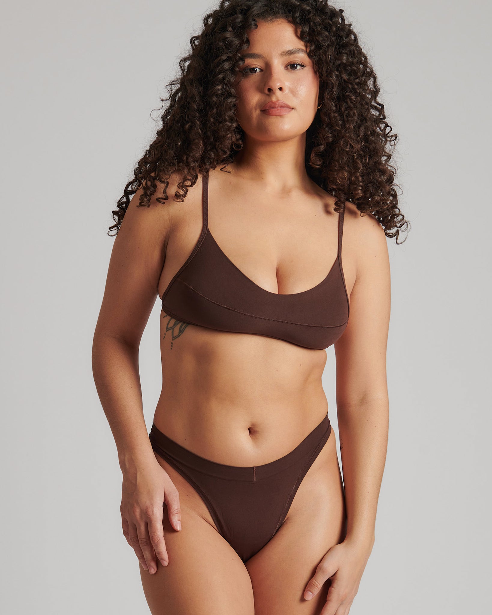 A person wearing a brown thong and scoop system on a plain background.