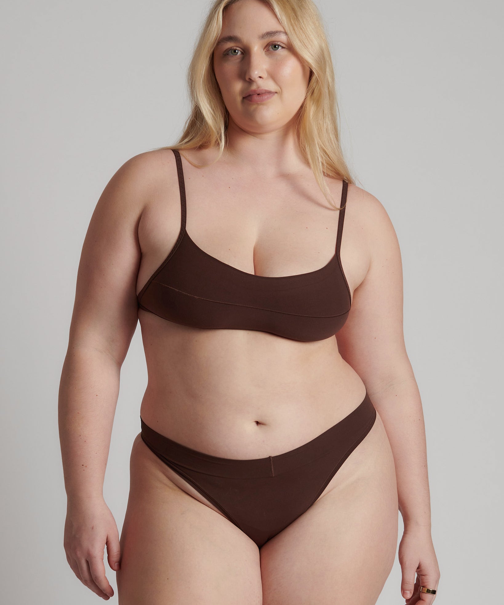 A person wearing a brown thong and scoop system on a plain background.