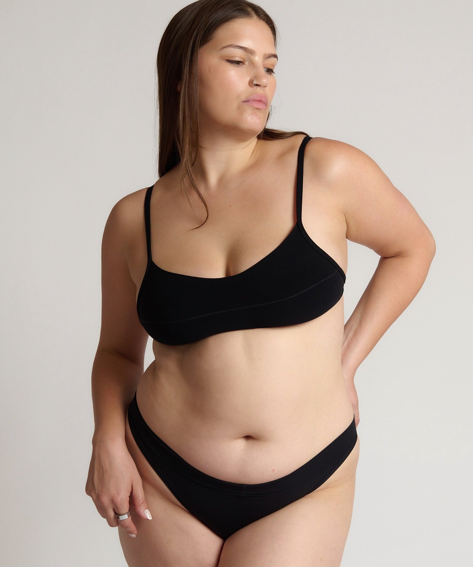 Woman wearing black scoop system against a neutral background