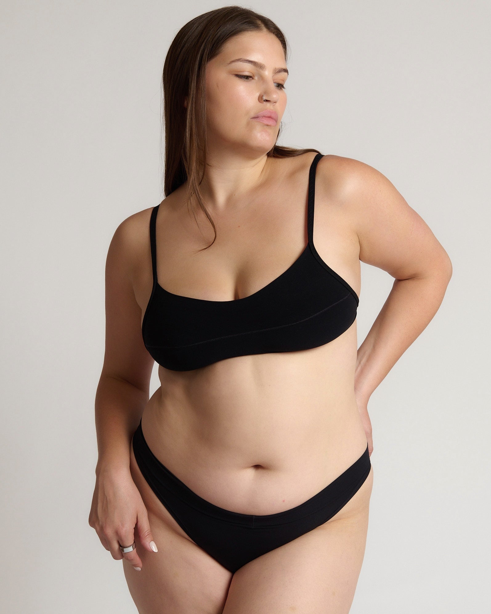 Woman wearing black scoop system against a neutral background