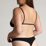 Woman wearing black scoop system against a neutral background