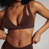 A brown-colored Tee System, designed with multiple strap options, worn by a model.