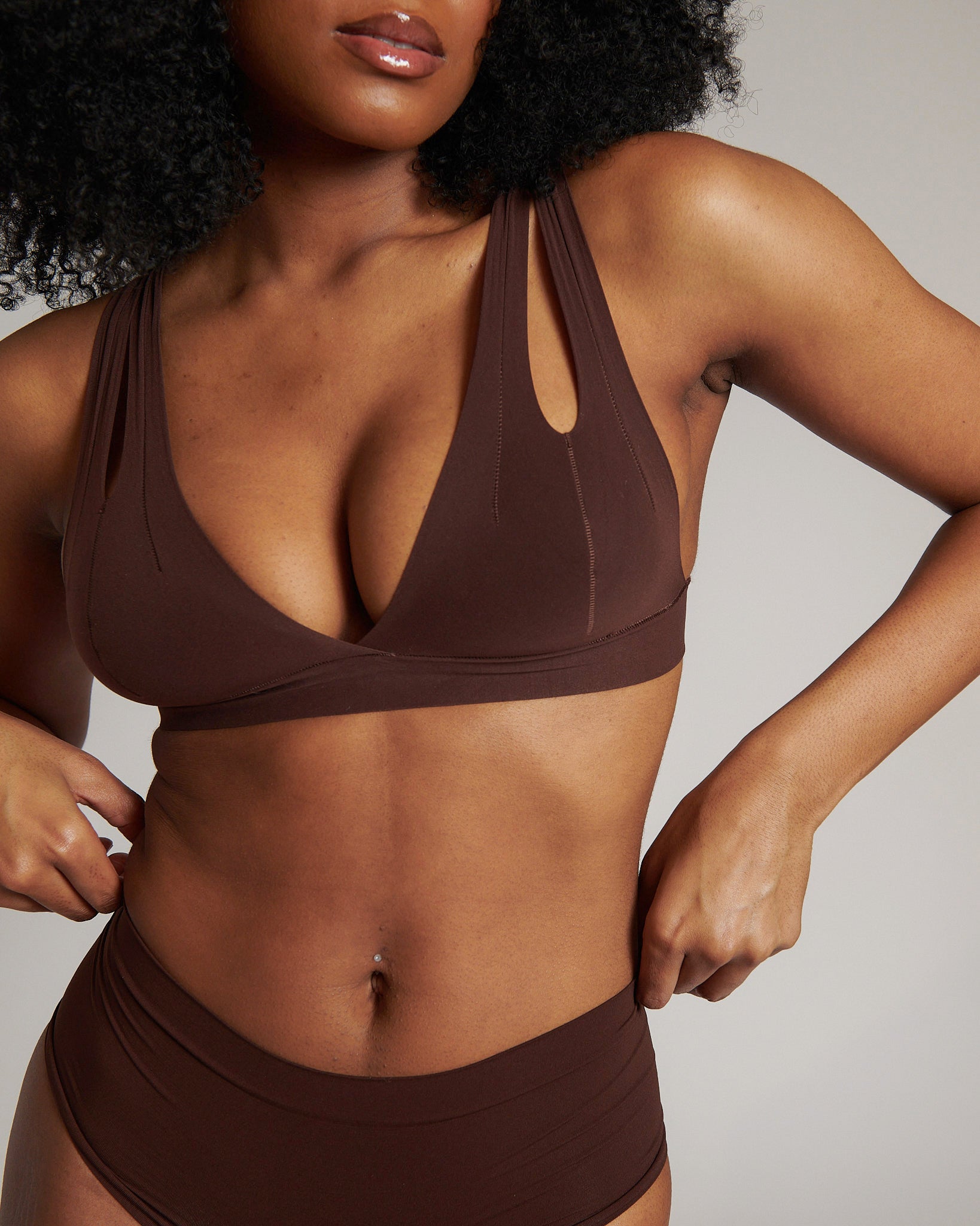 A brown-colored Tee System, designed with multiple strap options, worn by a model.