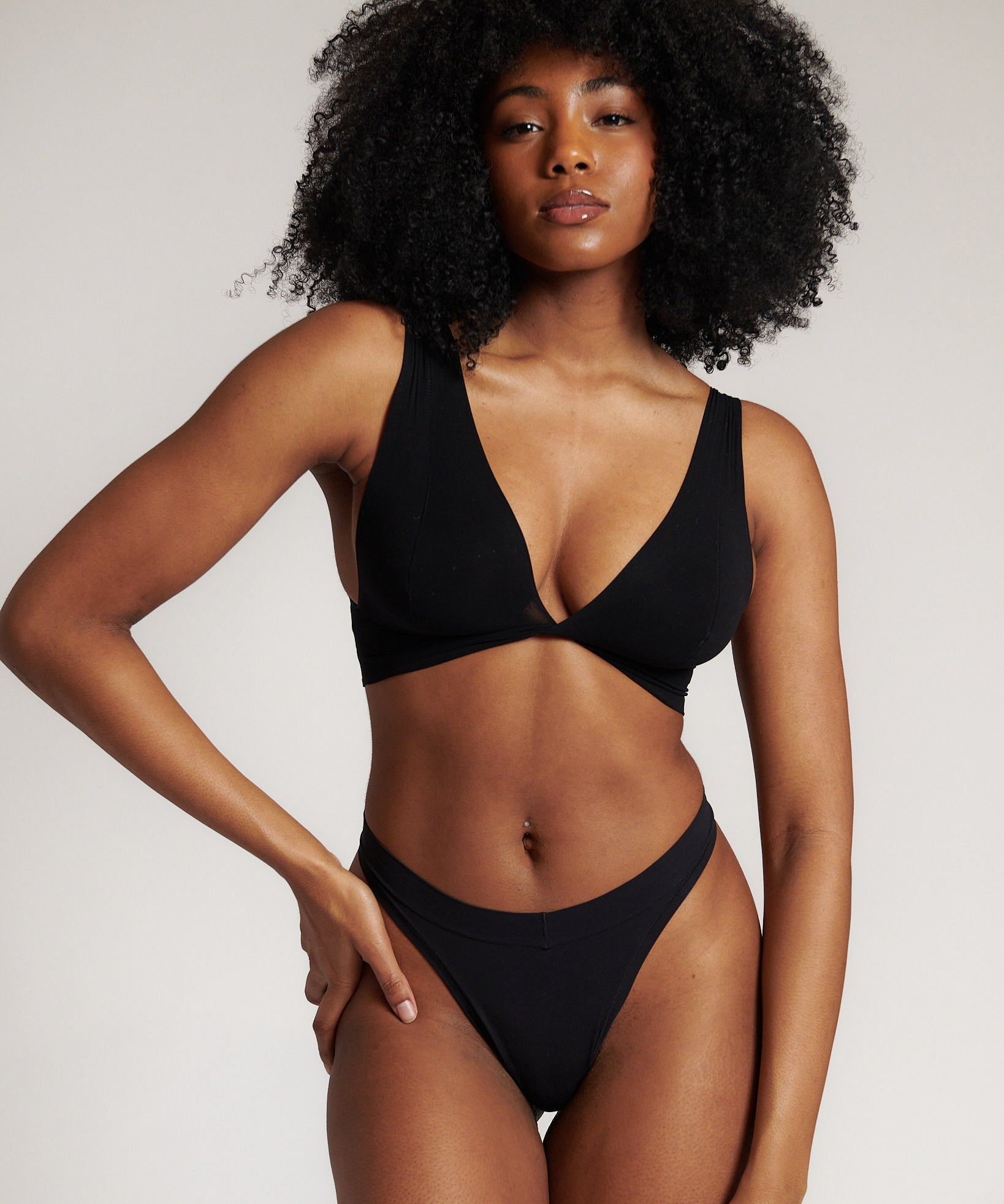 A woman is wearing a black twist system and thong
