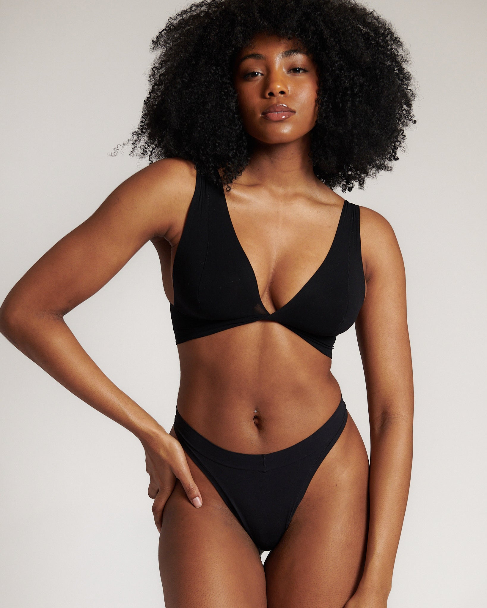 A woman is wearing a black twist system and thong