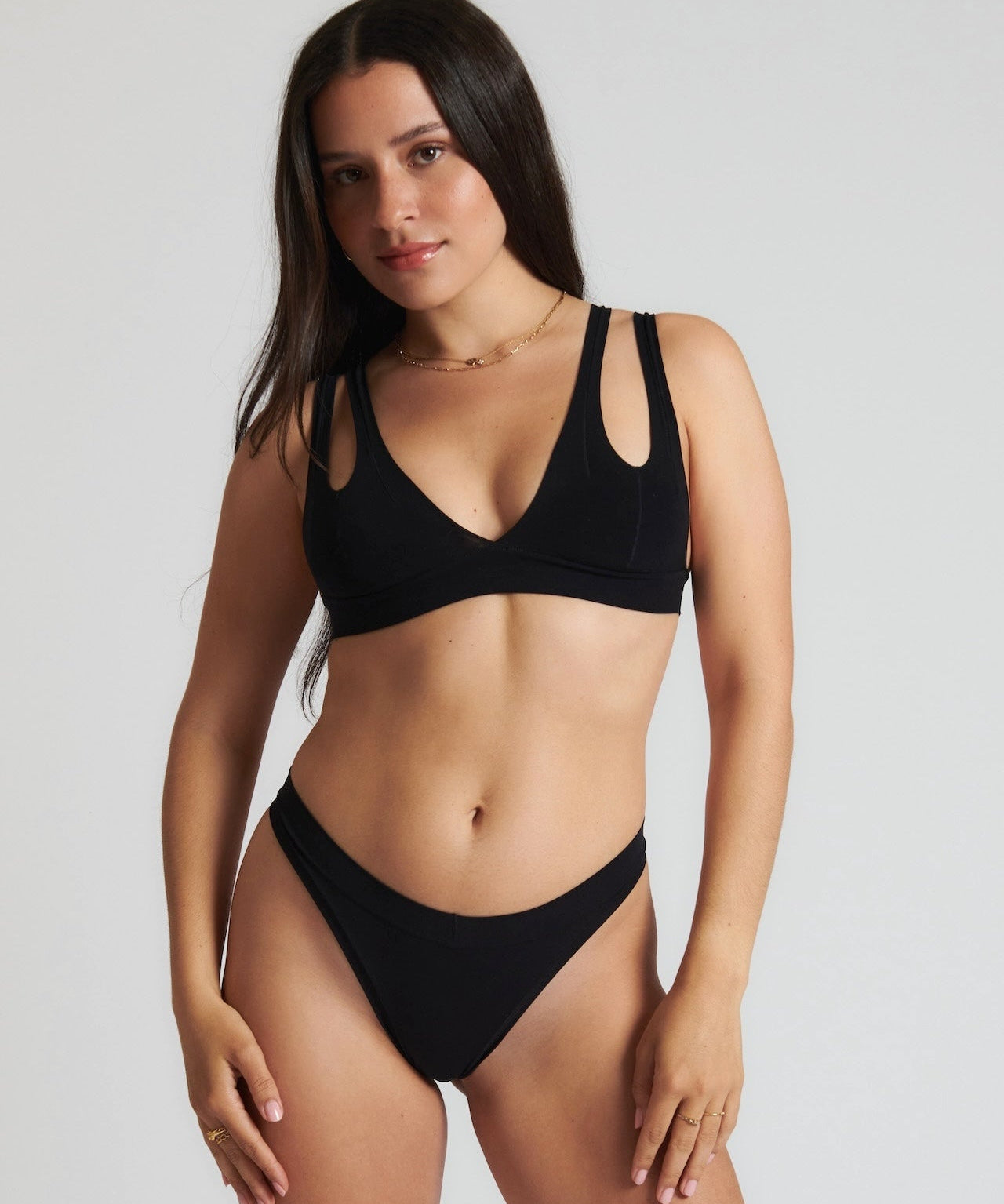 Woman wearing black tee system on plain background