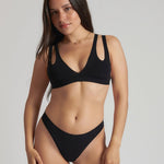 Woman wearing black tee system on plain background