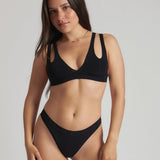 Woman wearing black tee system on plain background