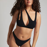 Woman wearing black tee system on plain background