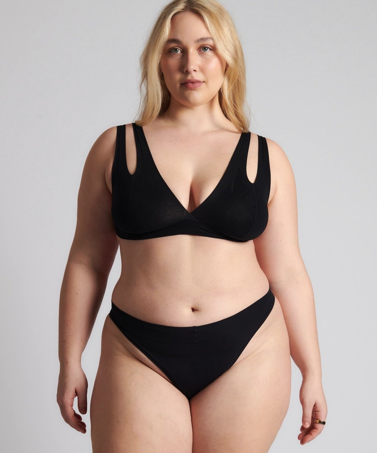 Woman wearing black tee system on plain background