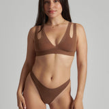 Woman wearing a brown bra against a neutral background