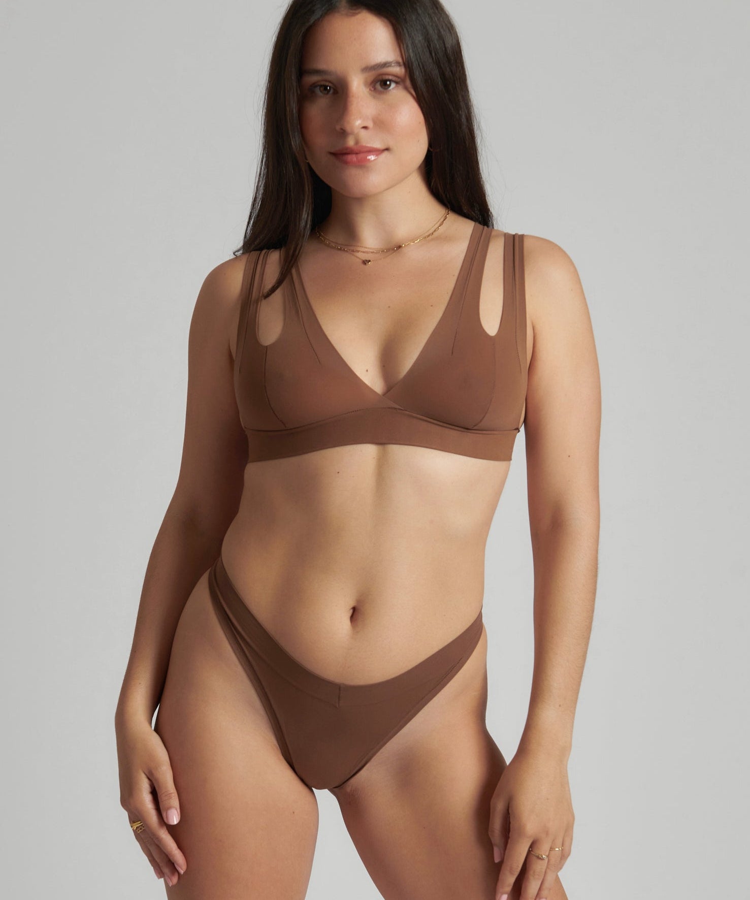 Woman wearing a brown bra against a neutral background