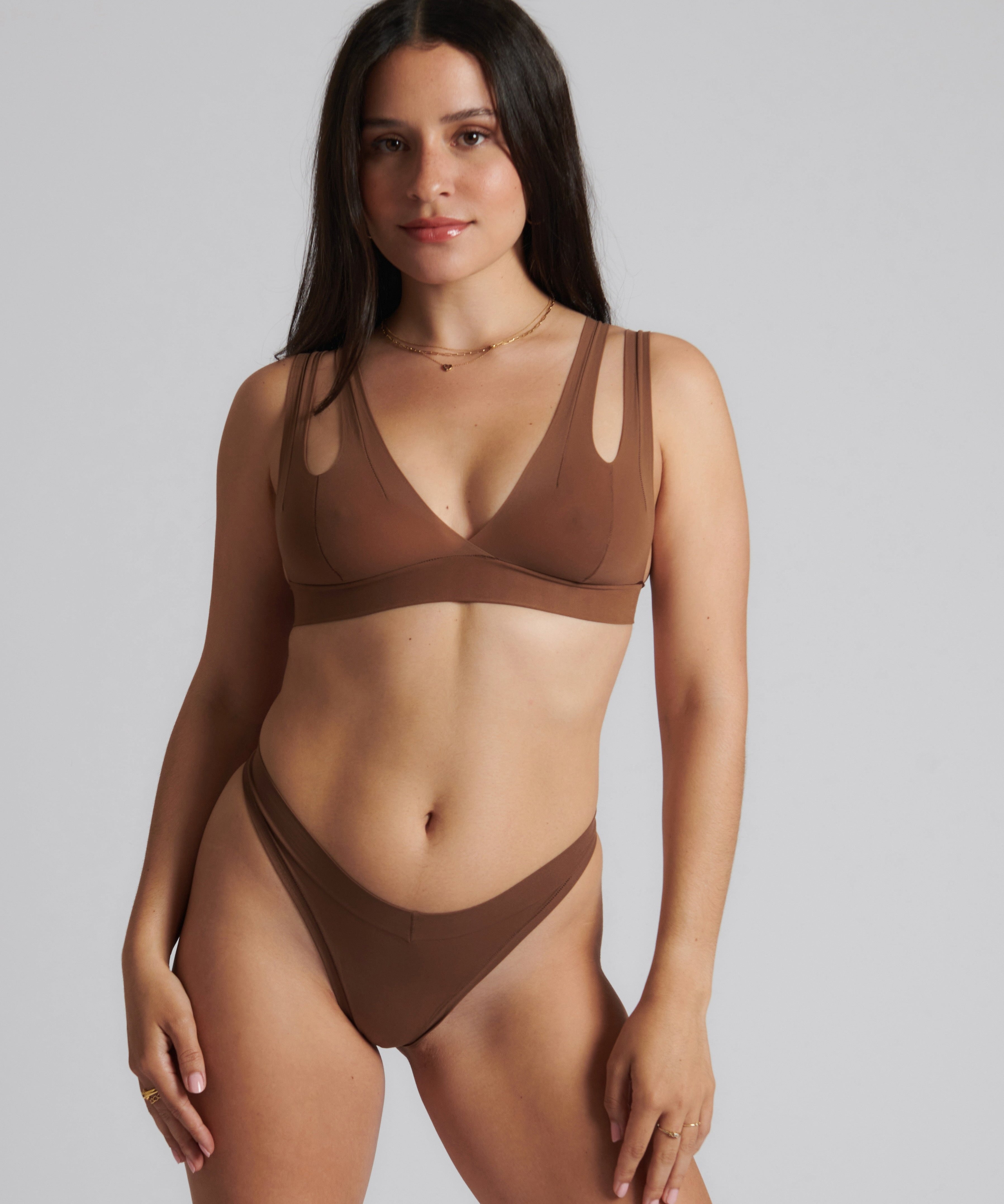 Woman wearing a brown bra against a neutral background