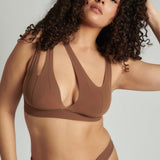 Woman wearing a brown bra against a neutral background