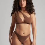 Woman wearing a brown bra against a neutral background