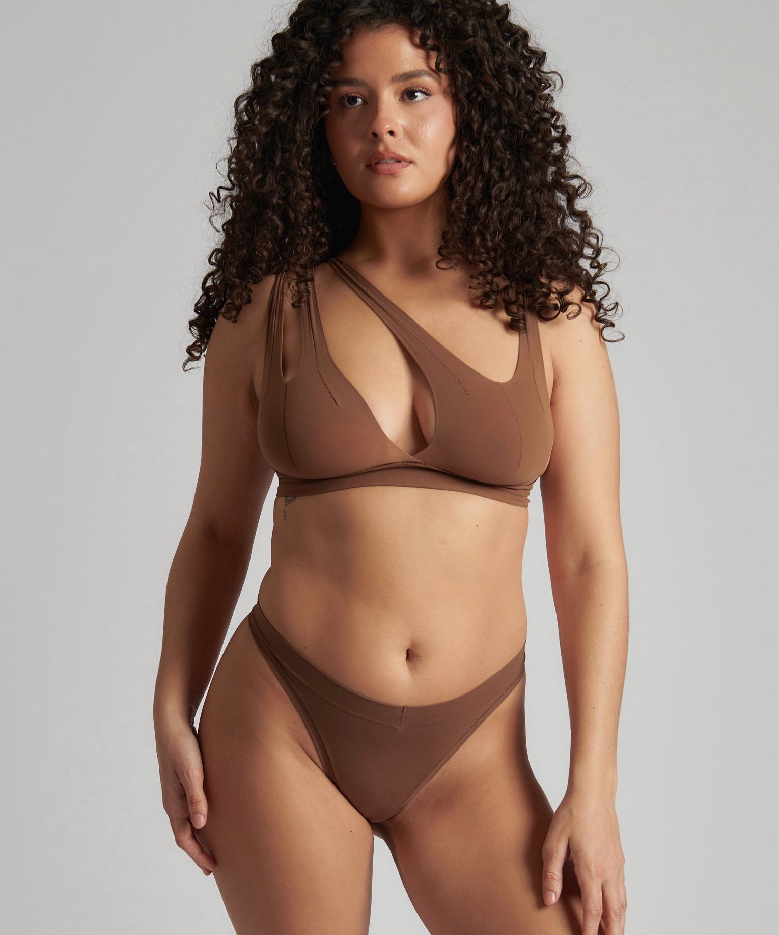 Woman wearing a brown bra against a neutral background