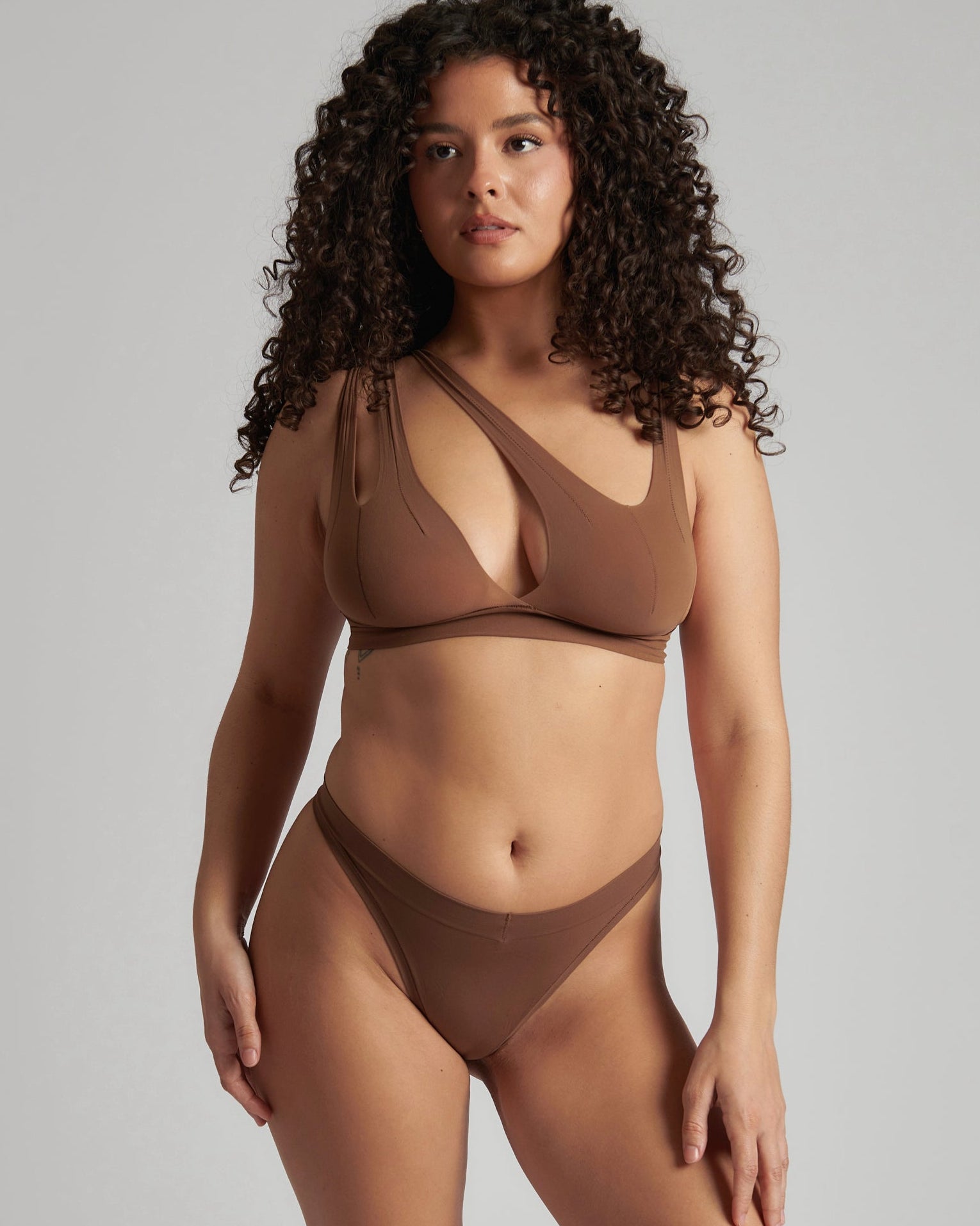 Woman wearing a brown bra against a neutral background