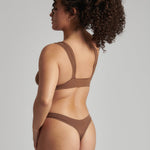 Woman wearing a brown bra against a neutral background