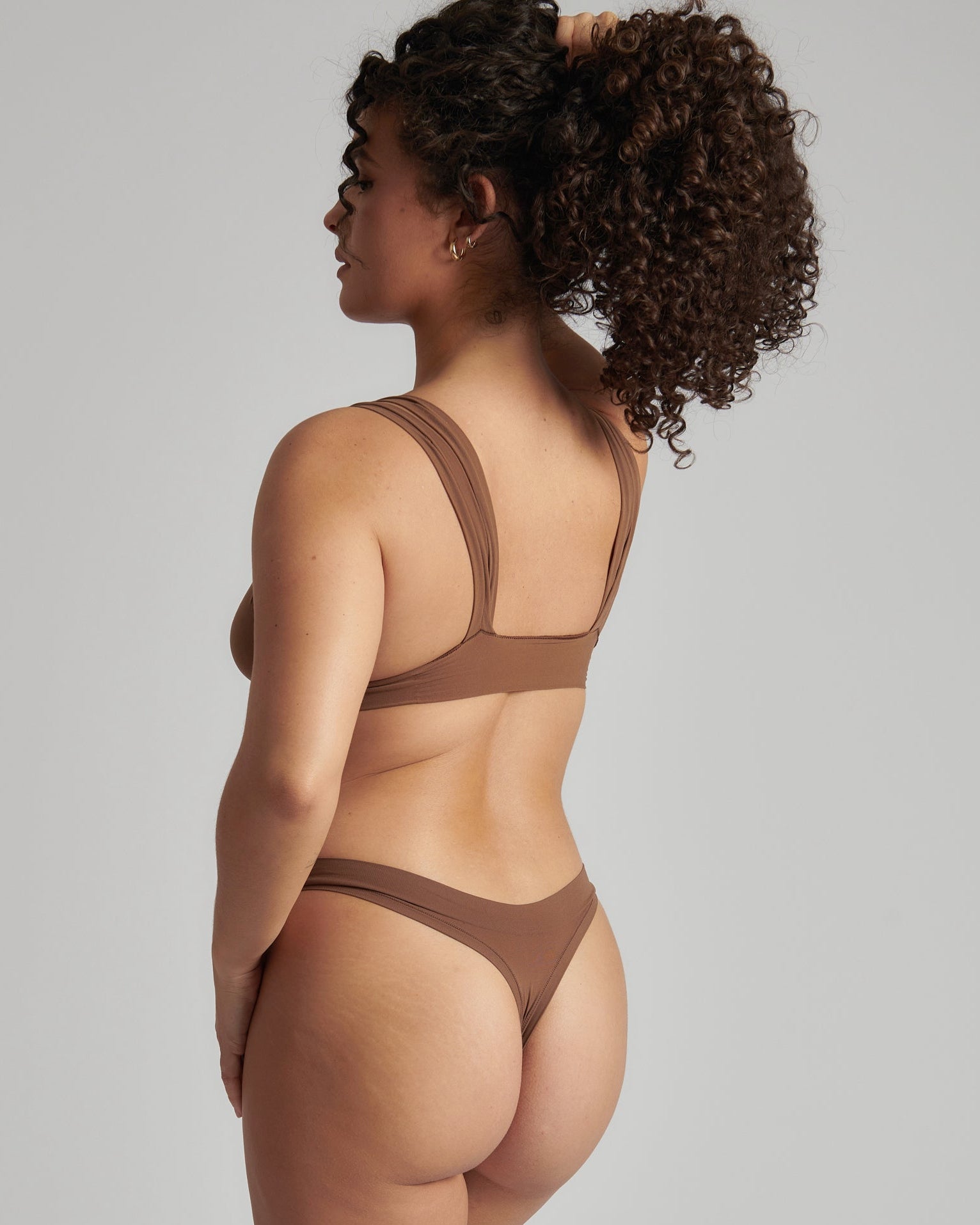 Woman wearing a brown bra against a neutral background