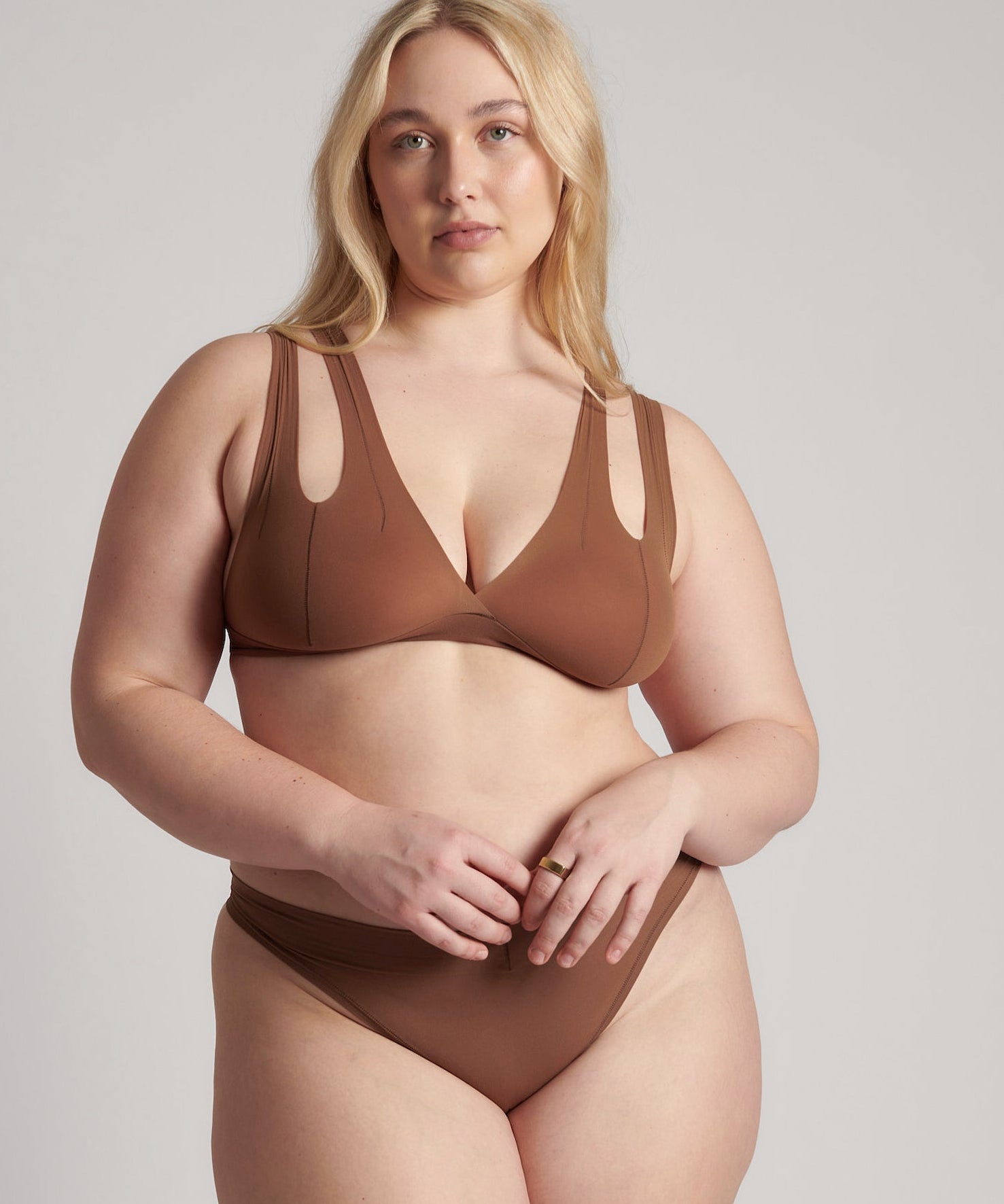 Woman wearing a brown bra against a neutral background