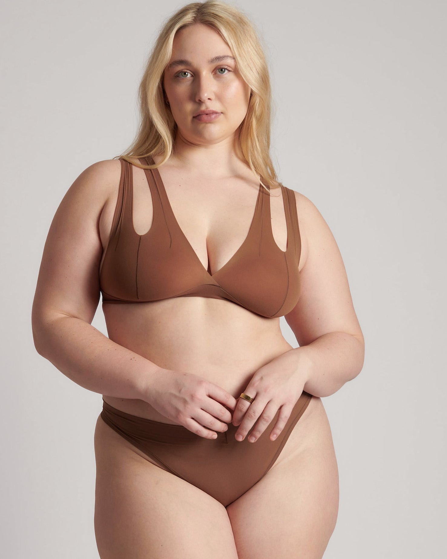 Woman wearing a brown bra against a neutral background