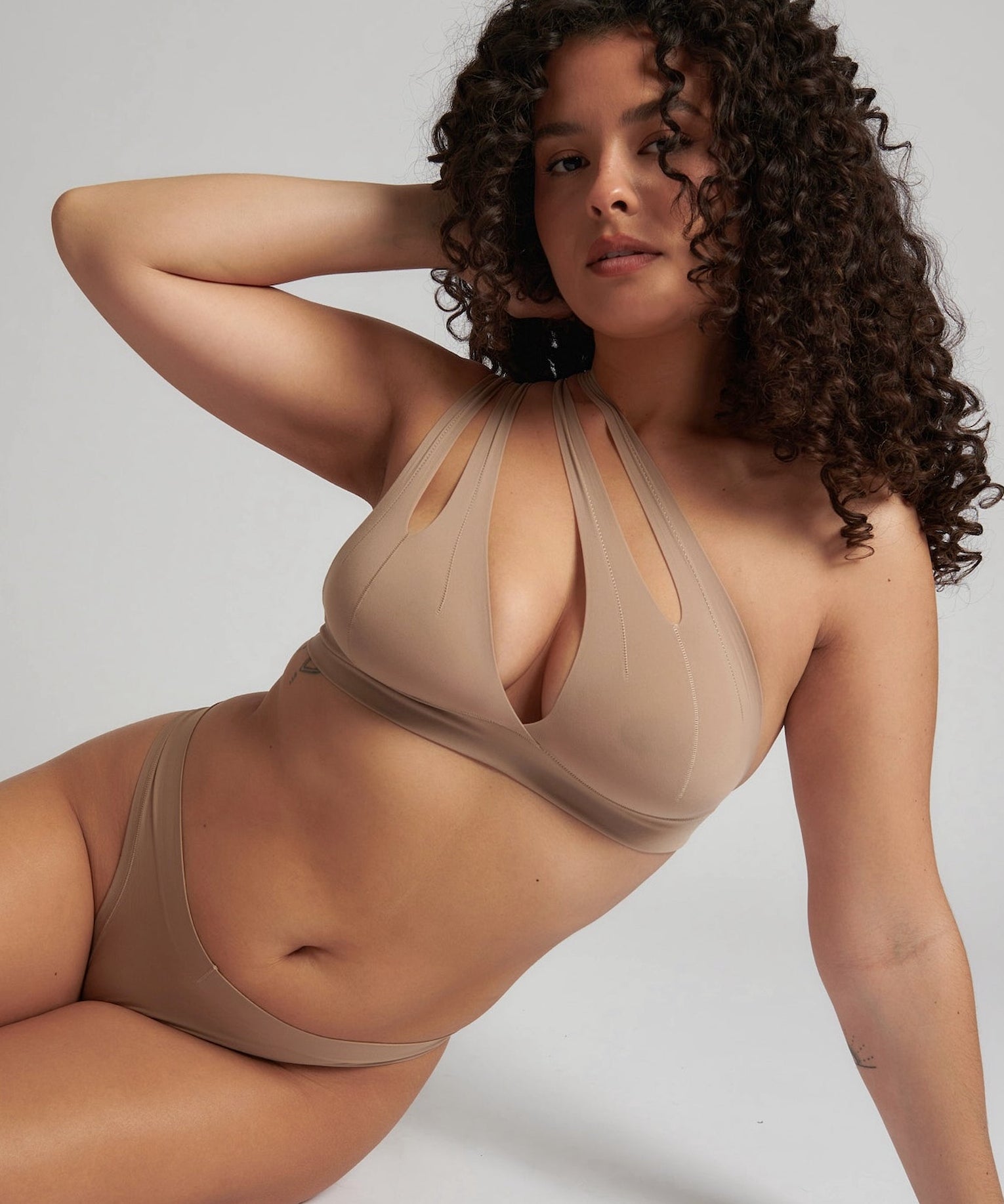 Woman wearing a light tee system against a plain background