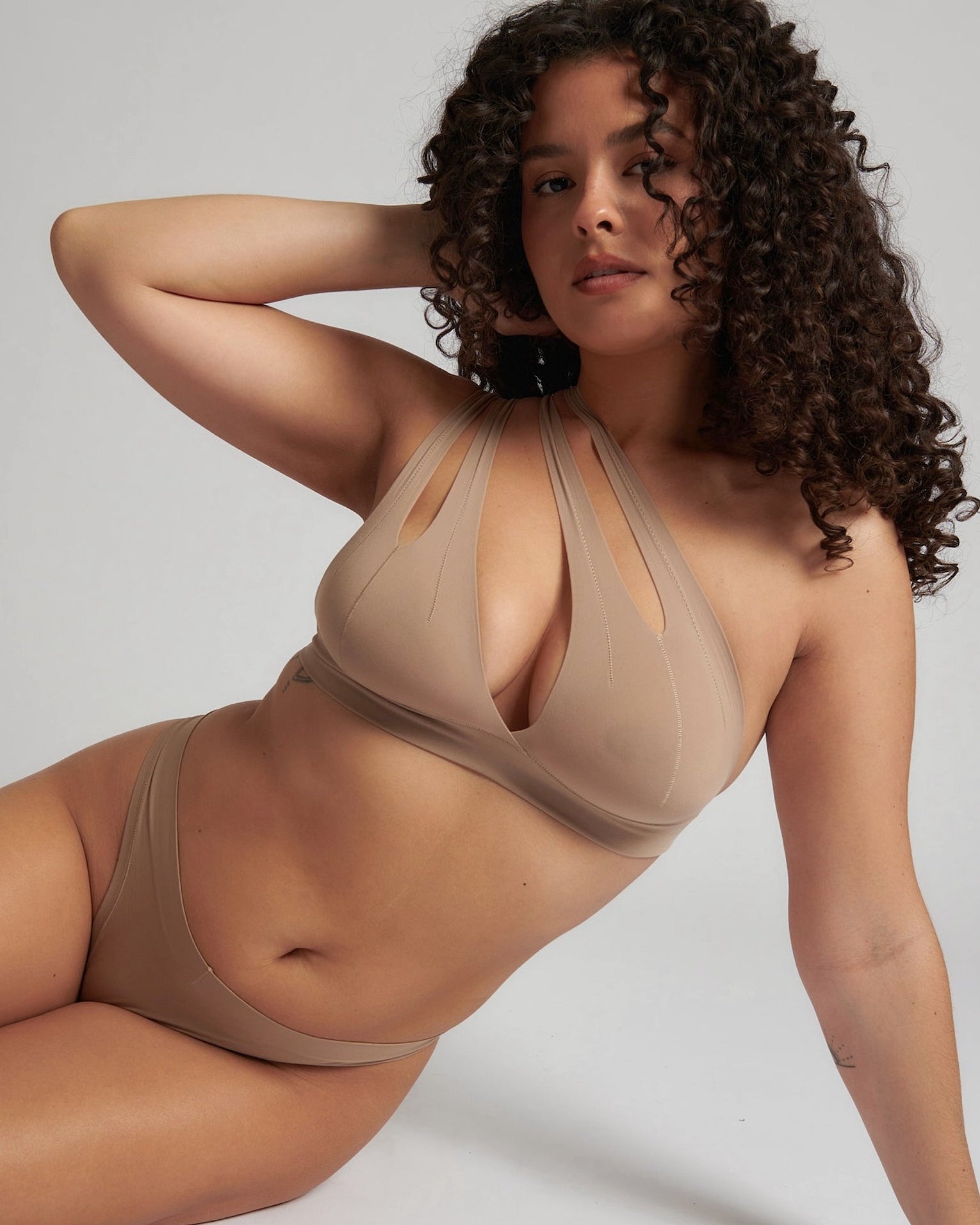 Woman wearing a light tee system against a plain background