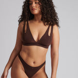 A brown-colored Tee System, designed with multiple strap options, worn by a model.