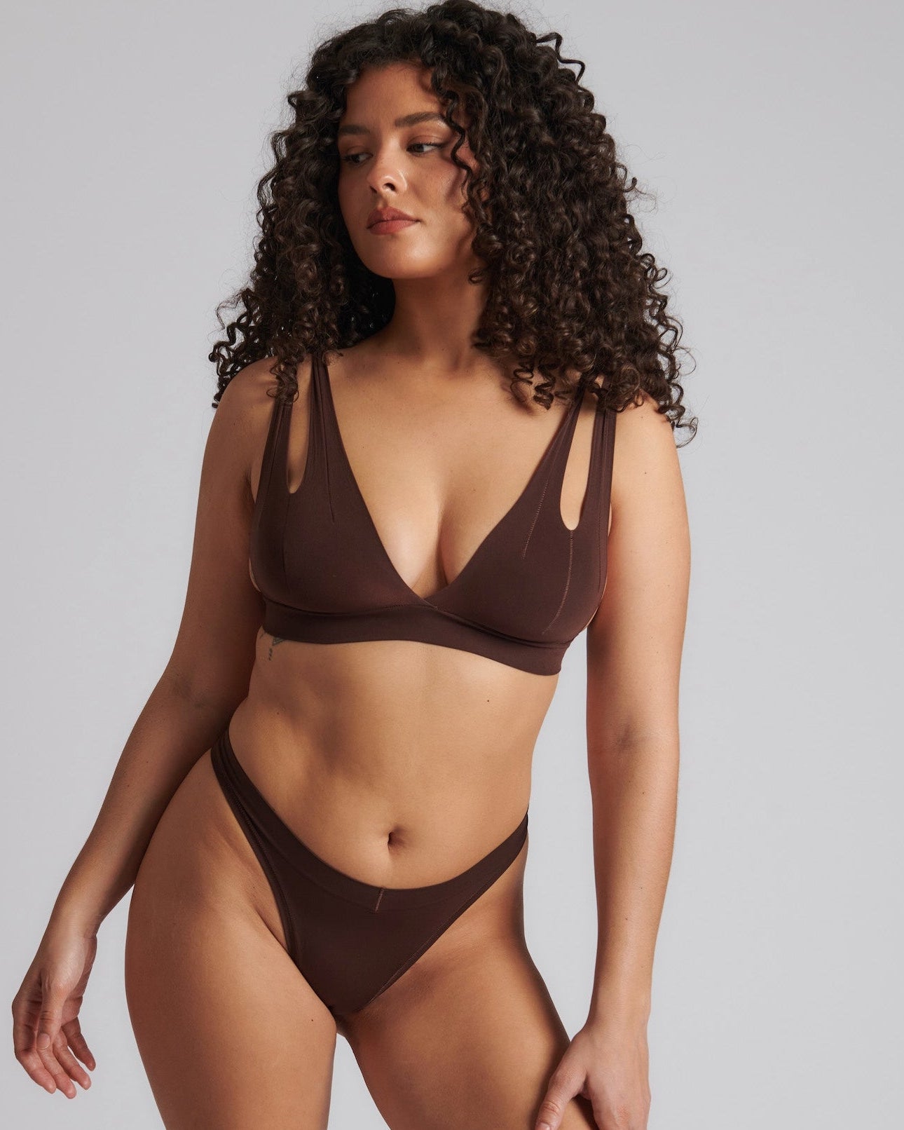 A brown-colored Tee System, designed with multiple strap options, worn by a model.